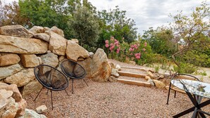 An outdoor seating area with stone walls, two metal chairs, a glass table, and a gravel path leading to a wooden staircase. - Bed and Breakfast 'Luxurious Love Room By Vill'amore' with Private Terrace, Wi-Fi and Air Conditioning (Solaro)
