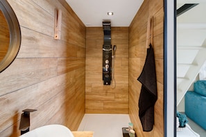 A modern bathroom with wooden walls, a shower, and a visible towel rack.