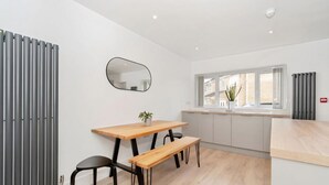 Una cocina moderna con ventanal, una mesa de madera y un banco.