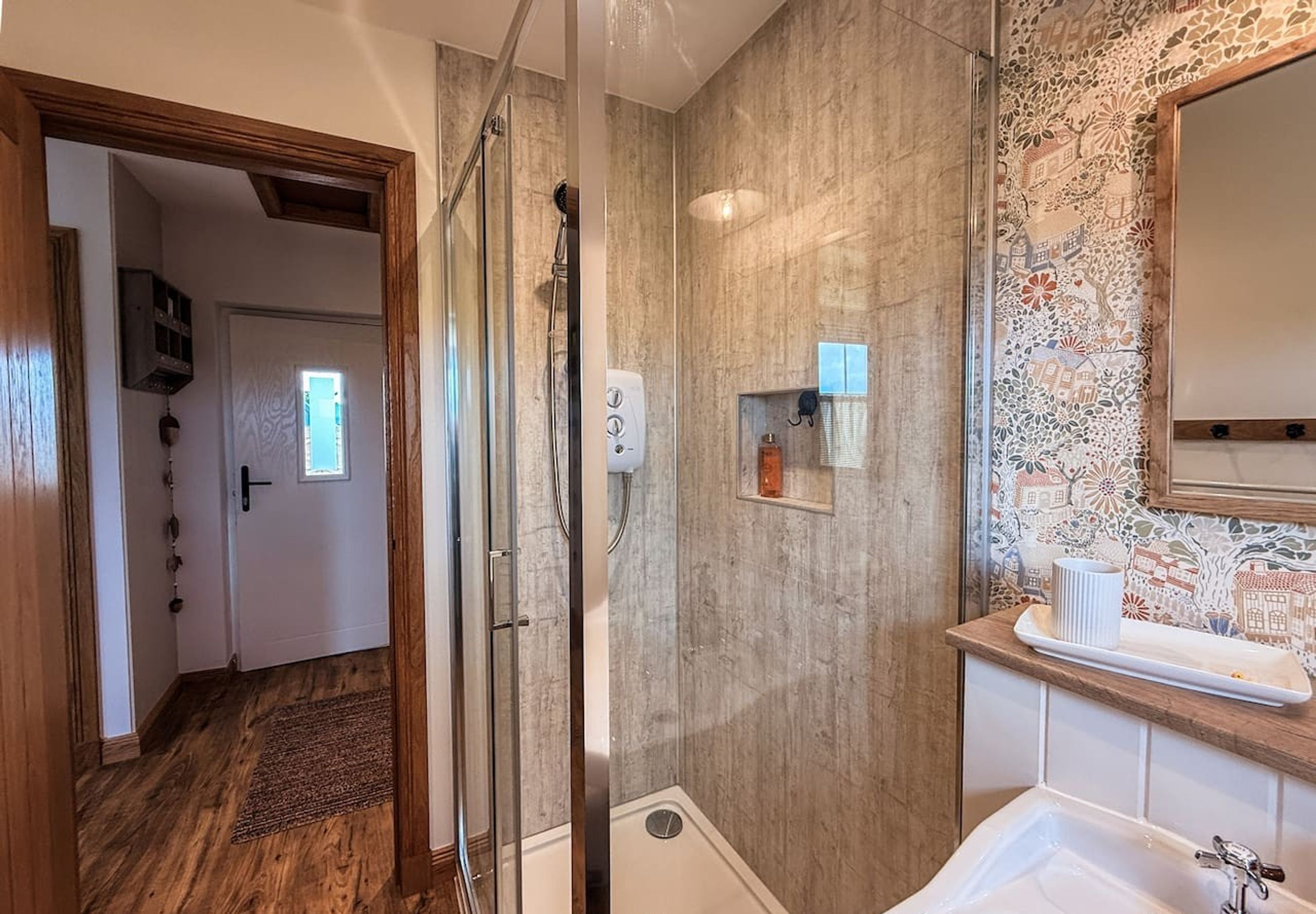 Une salle de bain avec une douche, un lavabo et un miroir.