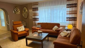 A living room with a sofa, armchair, and coffee table.