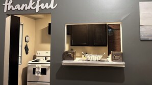 Una cocina con armarios oscuros, una encimera blanca y un letrero que dice 'agradecido'.