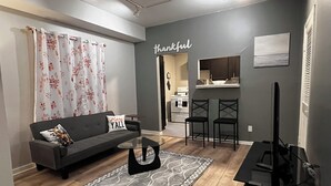 Una sala de estar moderna con un sofá, una mesa de centro y un televisor.