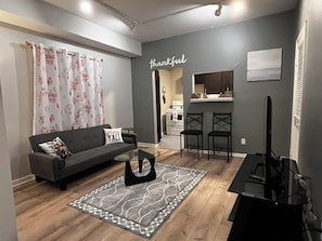 Ein modernes Wohnzimmer mit einer Couch, einem Couchtisch und einem Fernseher.