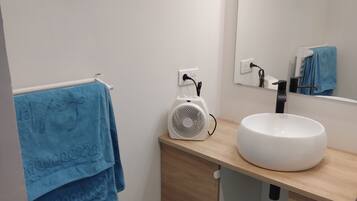 Een douche, handdoeken, zeep, toiletpapier