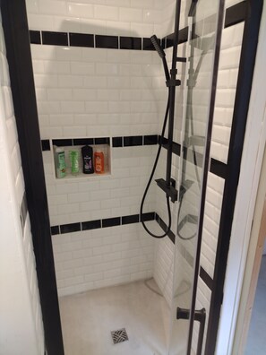 Een douche, handdoeken, zeep, toiletpapier