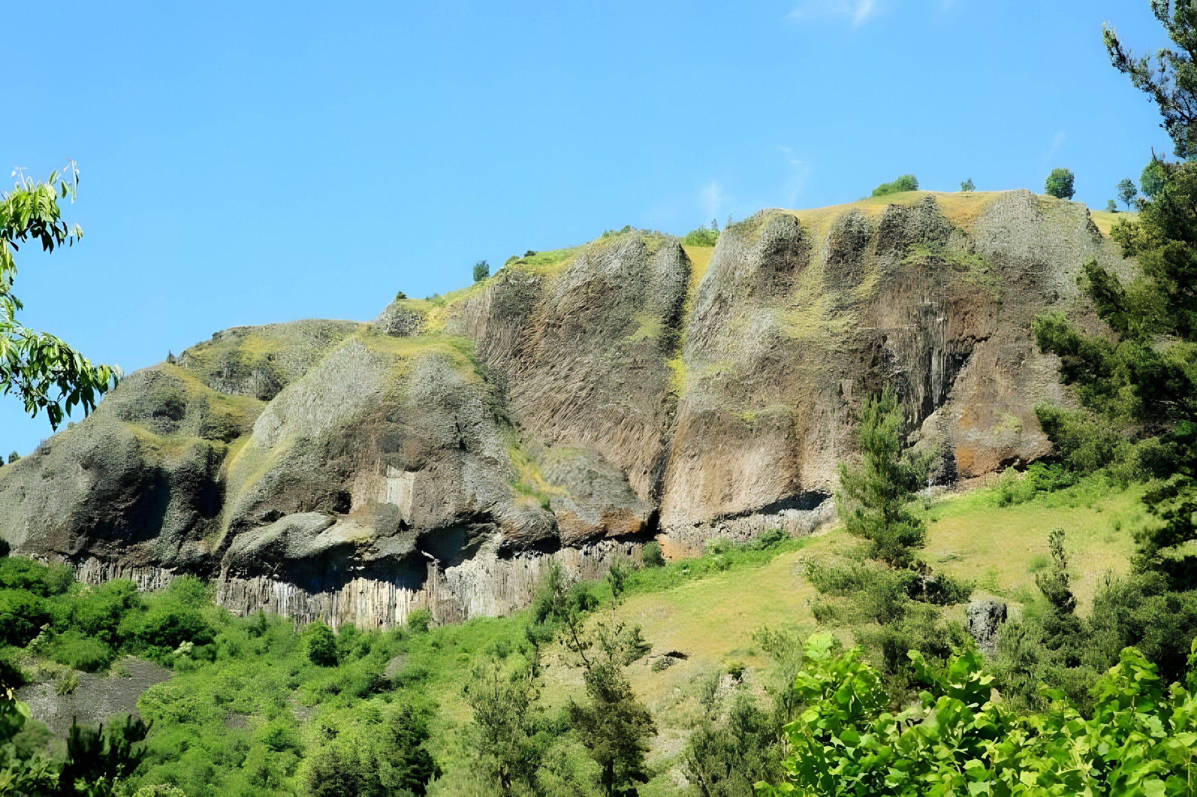 A natural landscape with rocky hills and greenery.
