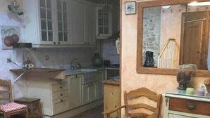 Une cuisine avec des meubles blancs, une chaise en bois dotée d’un coussin jaune et un miroir au-dessus de l’évier.
