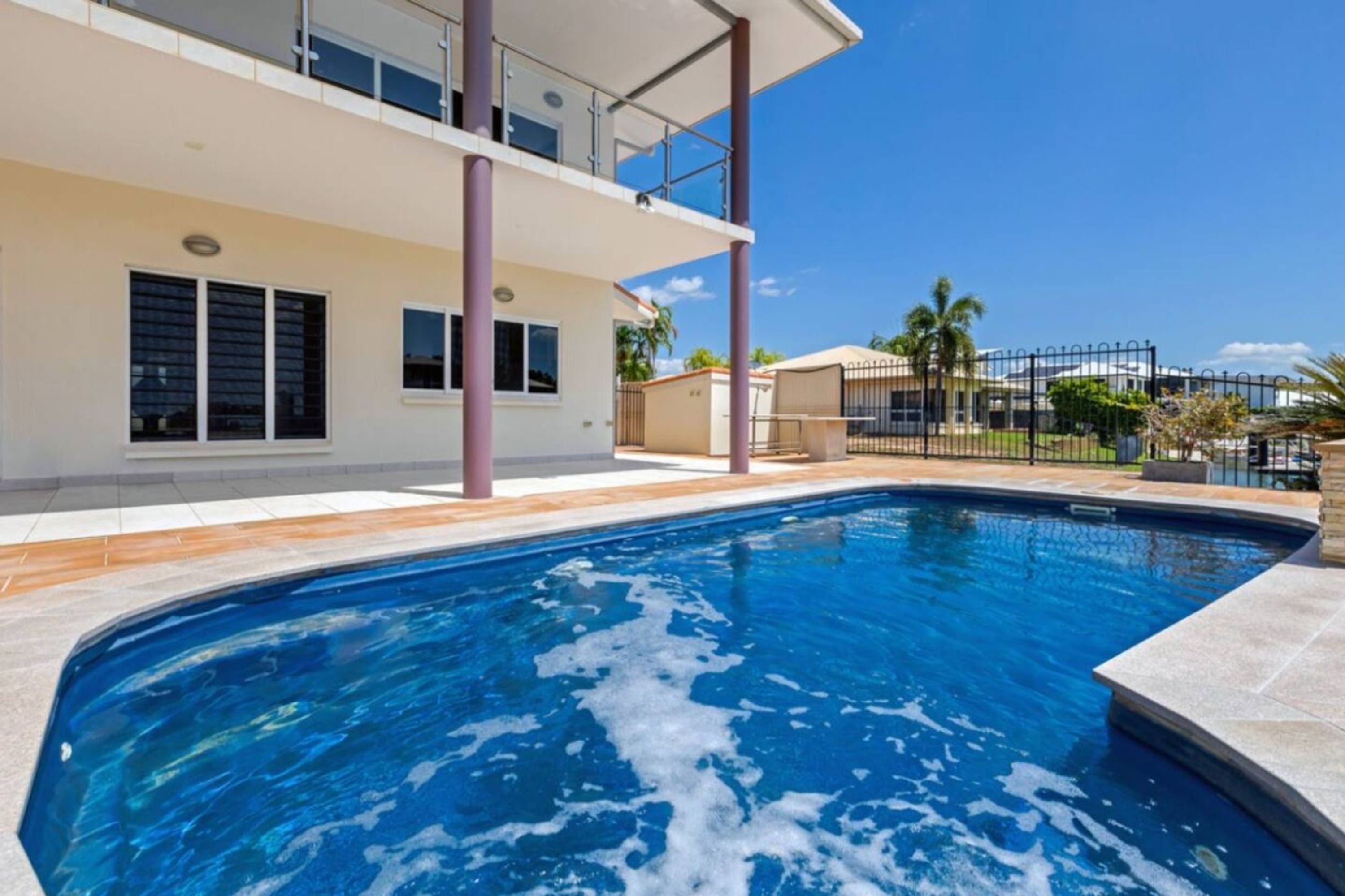 A swimming pool with a two-story building in the background.