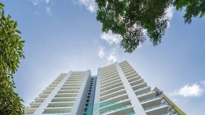 Un immeuble de grande hauteur doté de nombreux balcons, un ciel dégagé et le chiffre « 27 » bien visible sur la façade.