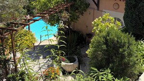 Una piscina con una pergola, immersa nel verde e con vista sul mare.
