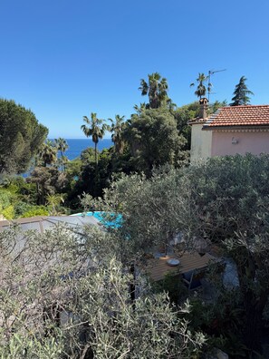 A residential area with a pool, dense vegetation, and a view of the ocean. - Small villa close to the sea with swimming pool and garden of eden. holiday/reunion (Vallauris)