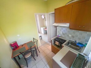 Cocina compacta con comedor, estufa y lavabo.