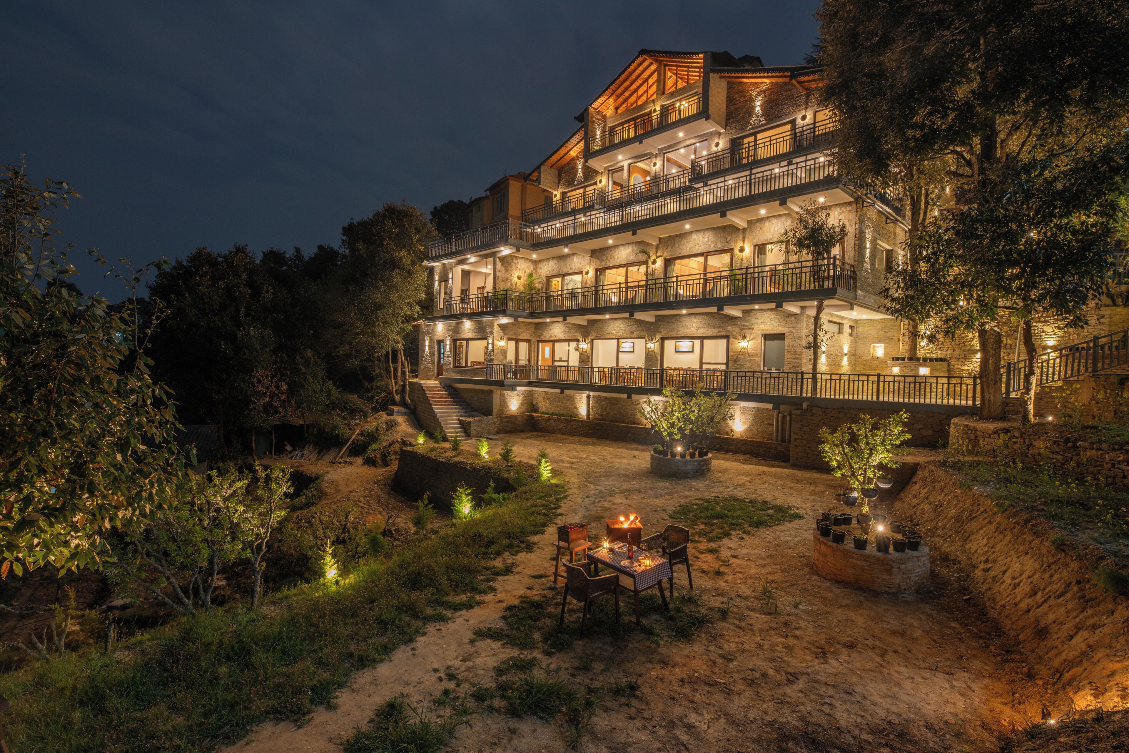 A multi-story hotel with outdoor seating and a fire pit.
