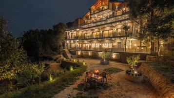 A multi-story hotel with outdoor seating and a fire pit.