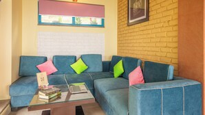 A living room with a sectional sofa, a glass coffee table, and a framed picture on the wall.