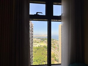 Ein Fenster mit Blick auf eine Stadtlandschaft, einschließlich Gebäude und Grünflächen.