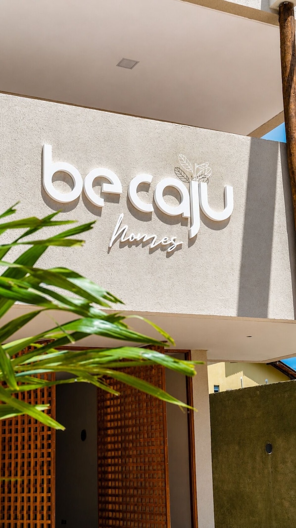 A building with a sign that reads 'becaju' and 'hombres'. - BE CAJU FLATS  (Cajueiro da Praia)