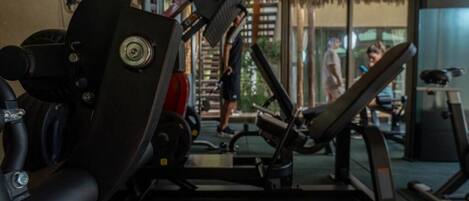A gym with exercise equipment, a weight bench, and a treadmill.