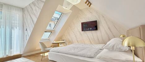 Een moderne slaapkamer met een bed, bureau en stoel.