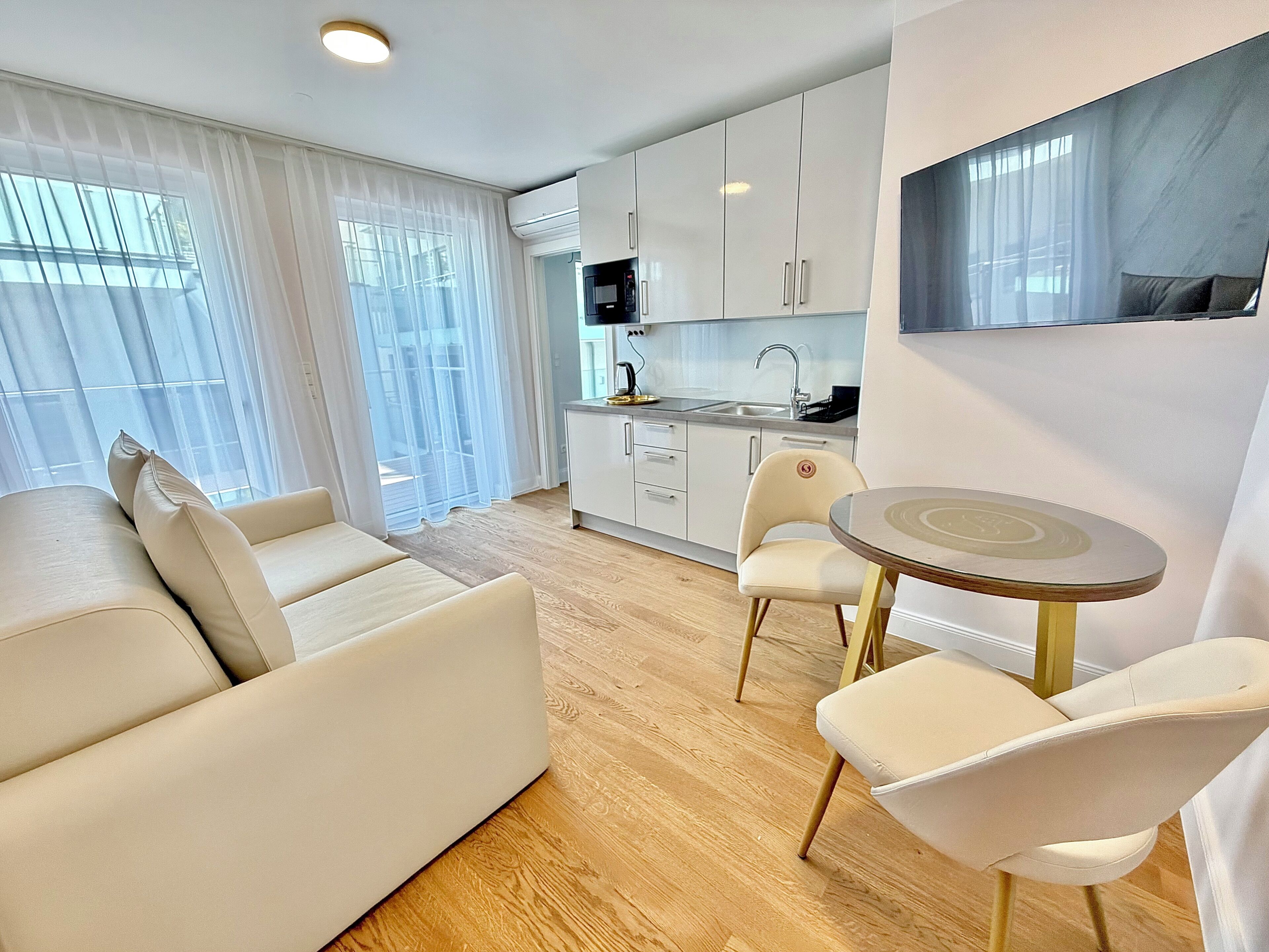 Un appartamento moderno con angolo living, tavolo da pranzo e cucina.