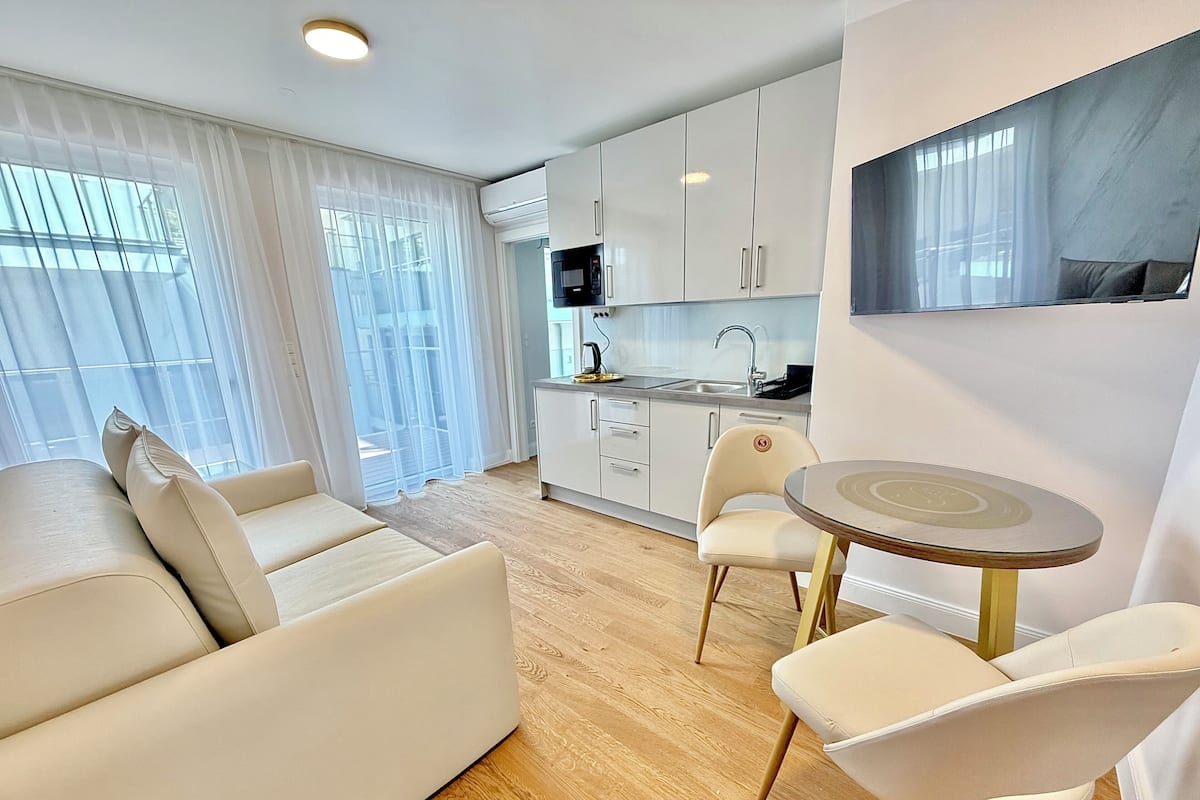 A modern apartment with a living area, a dining table, and a kitchen.
