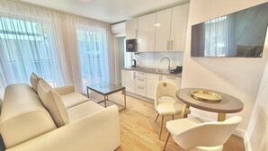 A modern apartment with a living area, a dining table, and a kitchenette. - Business Quartier Belvedere (Vienna)