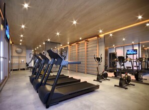 A gym with treadmills, exercise bikes, and weight machines. - Studio prático - Vila Mariana (São Paulo)
