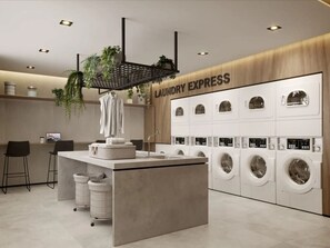 A modern laundry facility with multiple washing machines, a sink, and a bar area. - Studio prático - Vila Mariana (São Paulo)