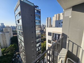 Ein Hochhaus mit vielen Stockwerken, großen Fenstern und einem Balkongeländer.