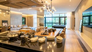 A modern kitchen with a central island, dining area, and a pool table. - Studio Bem Localizado - Moema (São Paulo)