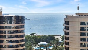 A view of a coastal hotel with a pool area, palm trees, and a beach in the background. - Stylish Marina 1BR with City View, Pool and Gym (Dubai)