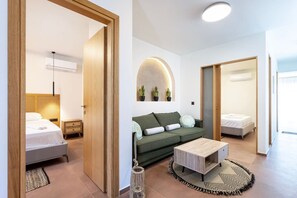 Ein modernes Hotelzimmer mit einem Bett, einer Couch, einem Couchtisch und einem kleinen Beistelltisch.