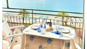 Une table dressée pour deux personnes, avec vue sur la mer.