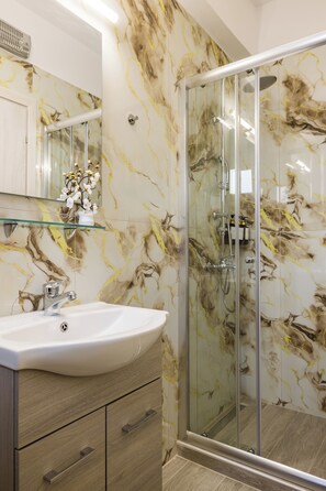 Apartamento superior | Baño | Ducha, artículos de higiene personal gratuitos y secador de pelo