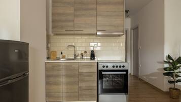 Frigorífico grande, horno, placa de cocina y utensilios de cocina