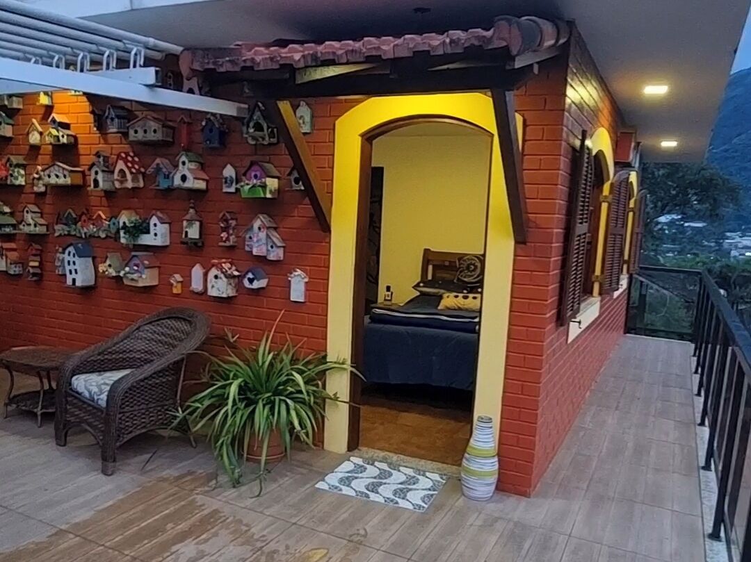 Une pièce comprenant un lit, une chaise, une plante en pot et un mur décoré de nichoirs.