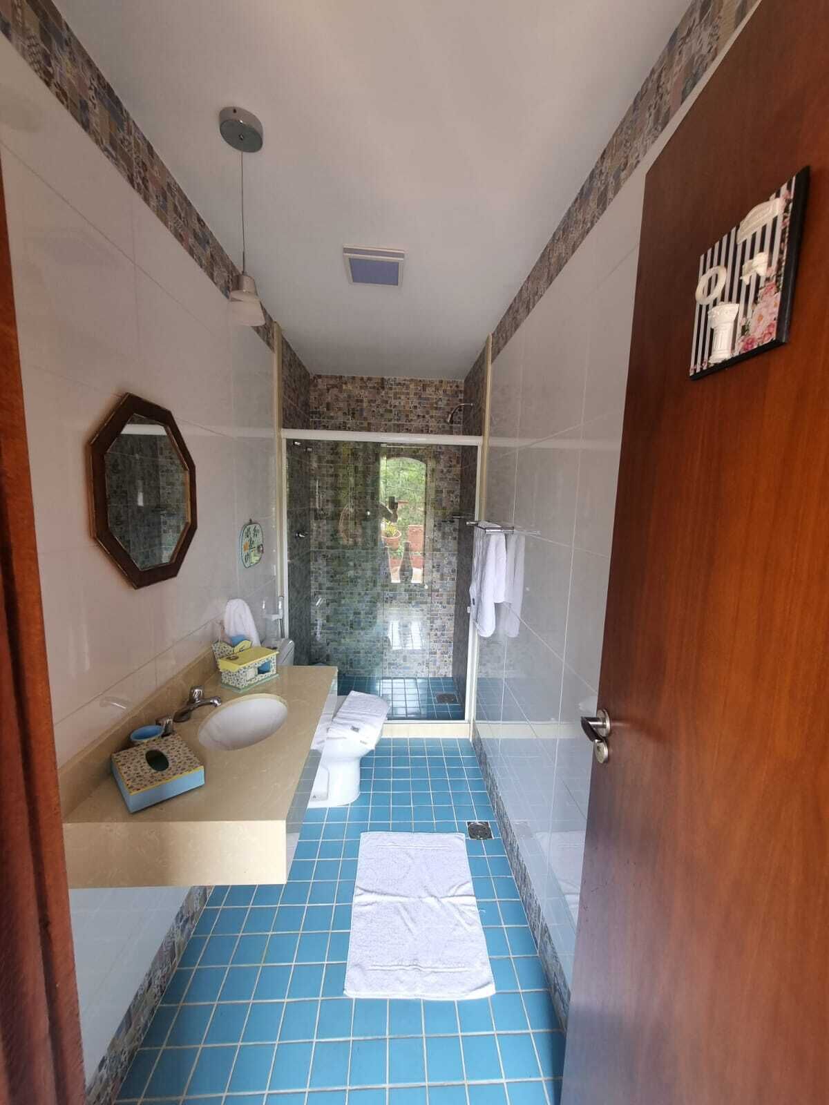 Une salle de bain équipée d’une douche, d’un lavabo, de toilettes et d’un miroir.