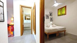 A bedroom with a bed, a ceiling fan, and a window with curtains. - Hostdomus - Plasch Apartment (Finale Ligure)