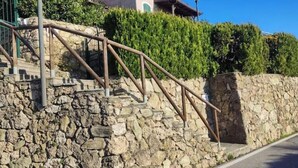 A stone staircase with metal railings leading up to a building. - Hostdomus - Plasch Apartment (Finale Ligure)