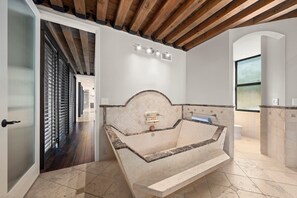 Un baño moderno con una bañera independiente, zona de ducha y un amplio ventanal que proporciona luz natural.