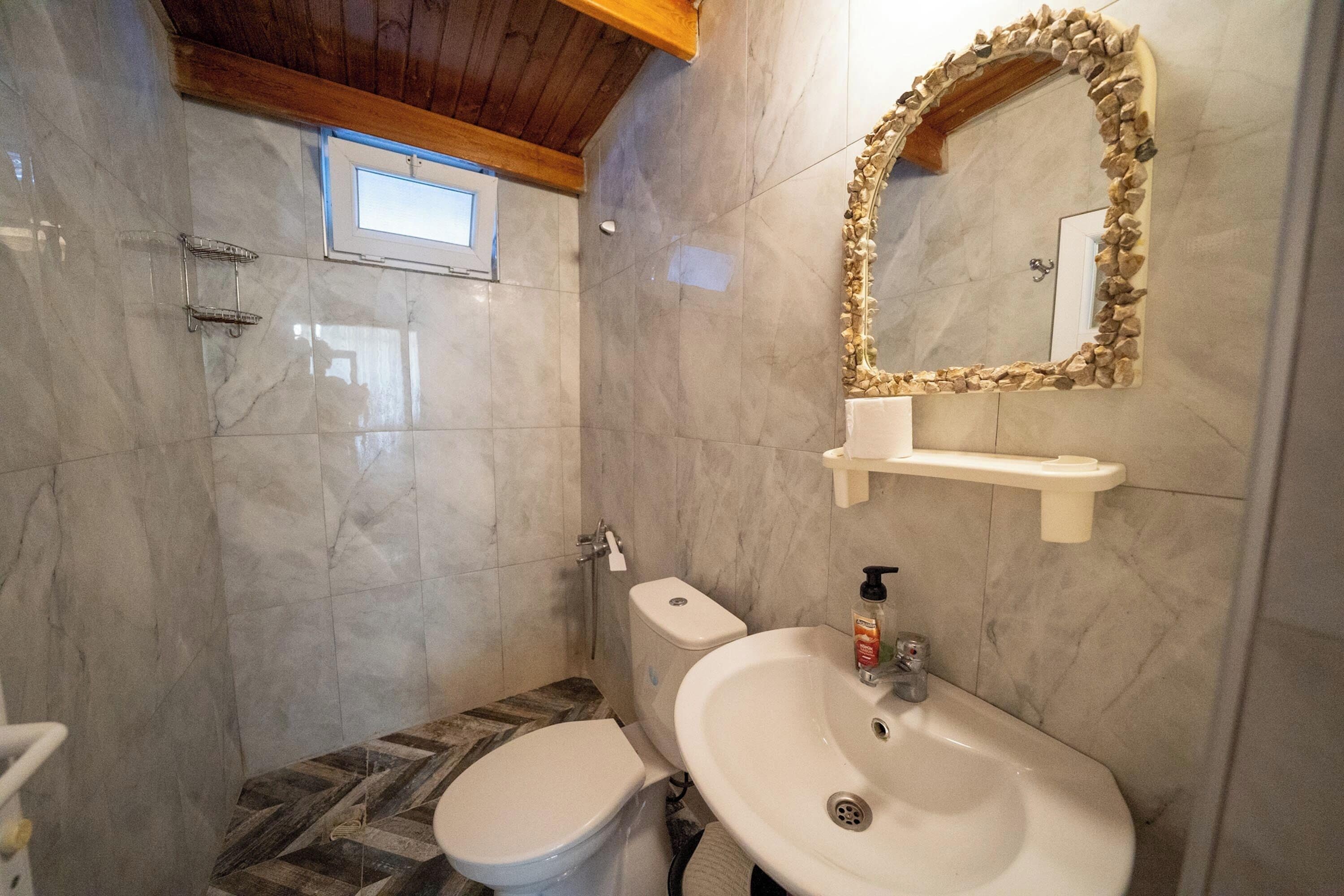 Un baño con inodoro, lavamanos y ducha.