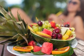 A fruit salad with watermelon, grapes, and pineapple on a plate.