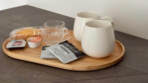A tray with two white mugs, a small container, a packet, and a glass on a wooden board. - Perfect house for Naples and Pompeii with balcony overlooking Vesuvius free parking (Casalnuovo di Napoli)