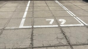 A parking area with marked spaces and a view of distant buildings and mountains. - Perfect house for Naples and Pompeii with balcony overlooking Vesuvius free parking (Casalnuovo di Napoli)
