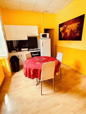 A compact kitchen with white cabinets, a microwave, and a gas stove. - F1 30M2 2/4 persons (La Bourboule)