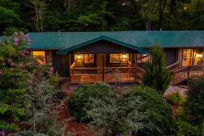 Eine Lodge mit grüner Dachbegrünung, Holzfassade und einer Veranda mit Geländer.