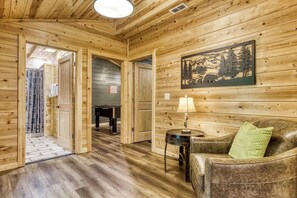 Ein Holzinterieur mit einer Couch, einer Lampe und einem Gemälde an der Wand.