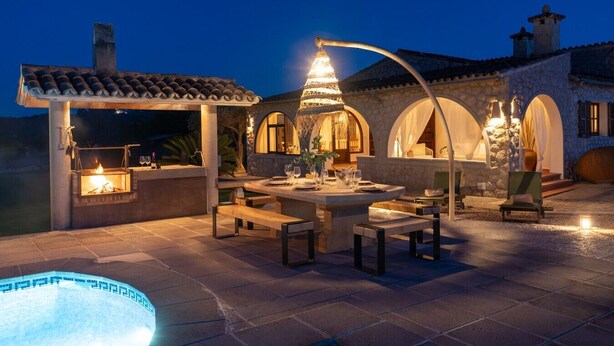 Un patio al aire libre con piscina, una parrilla y una mesa de comedor para dos.