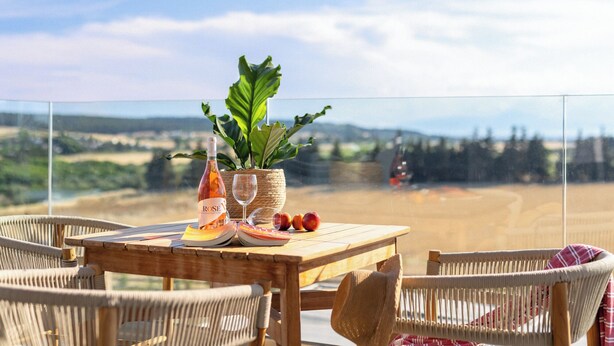 A wooden table with a bottle, glasses, and fruits, surrounded by wicker chairs, overlooking a scenic landscape. - Sani Gulf I & II (Kassandra)